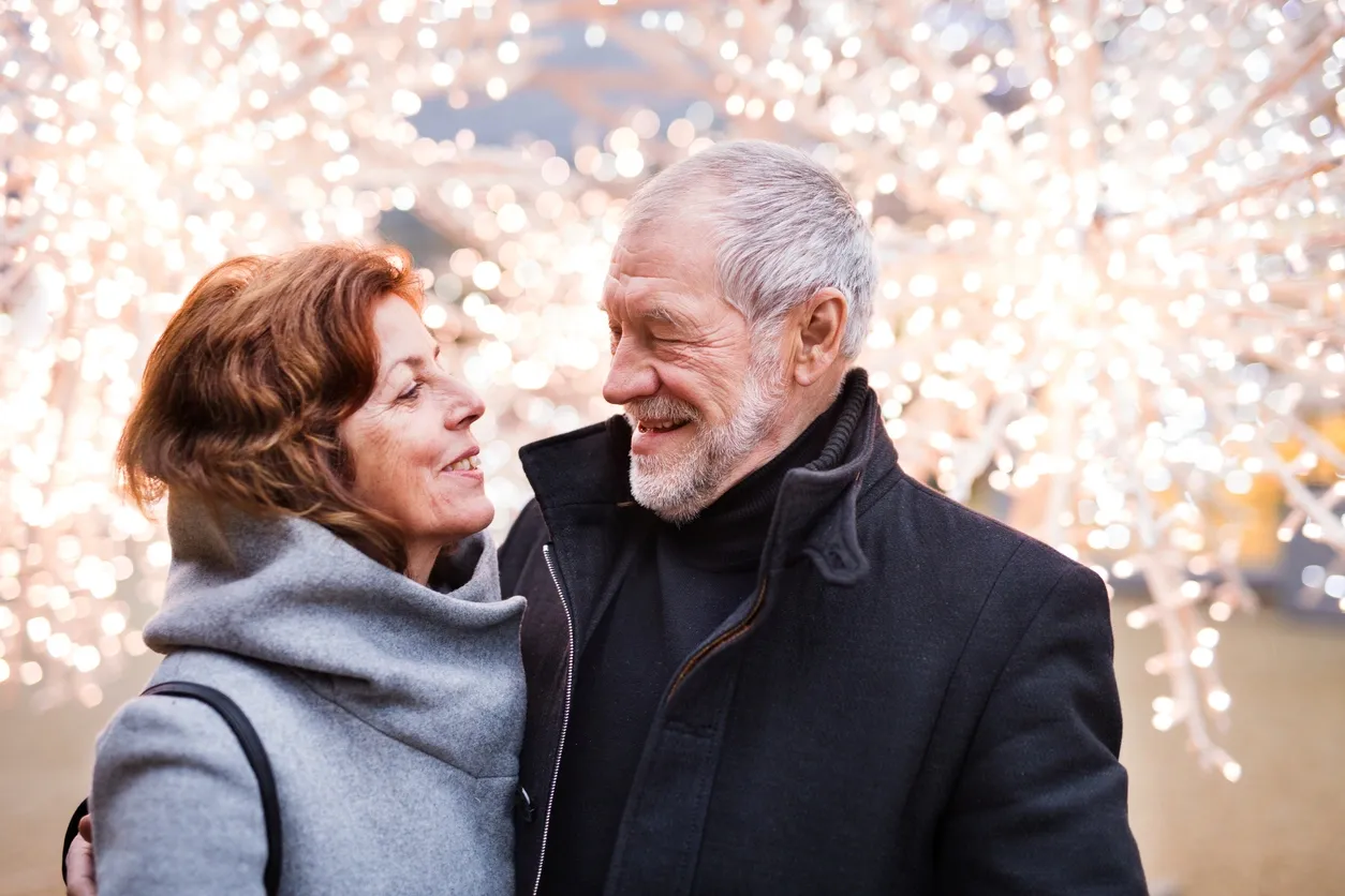 Older couple smiling at each other warmly, symbolizing trust, vulnerability, and emotional honesty in a lasting relationship.
